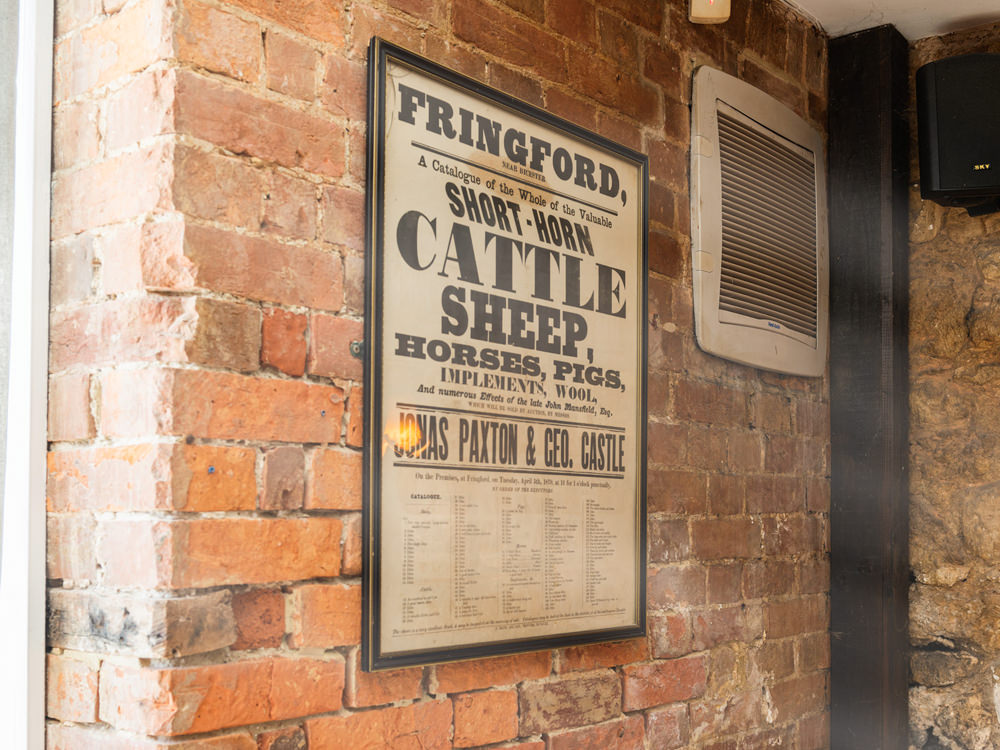 an old world cattle sign displayed on a wall at the horse and groom